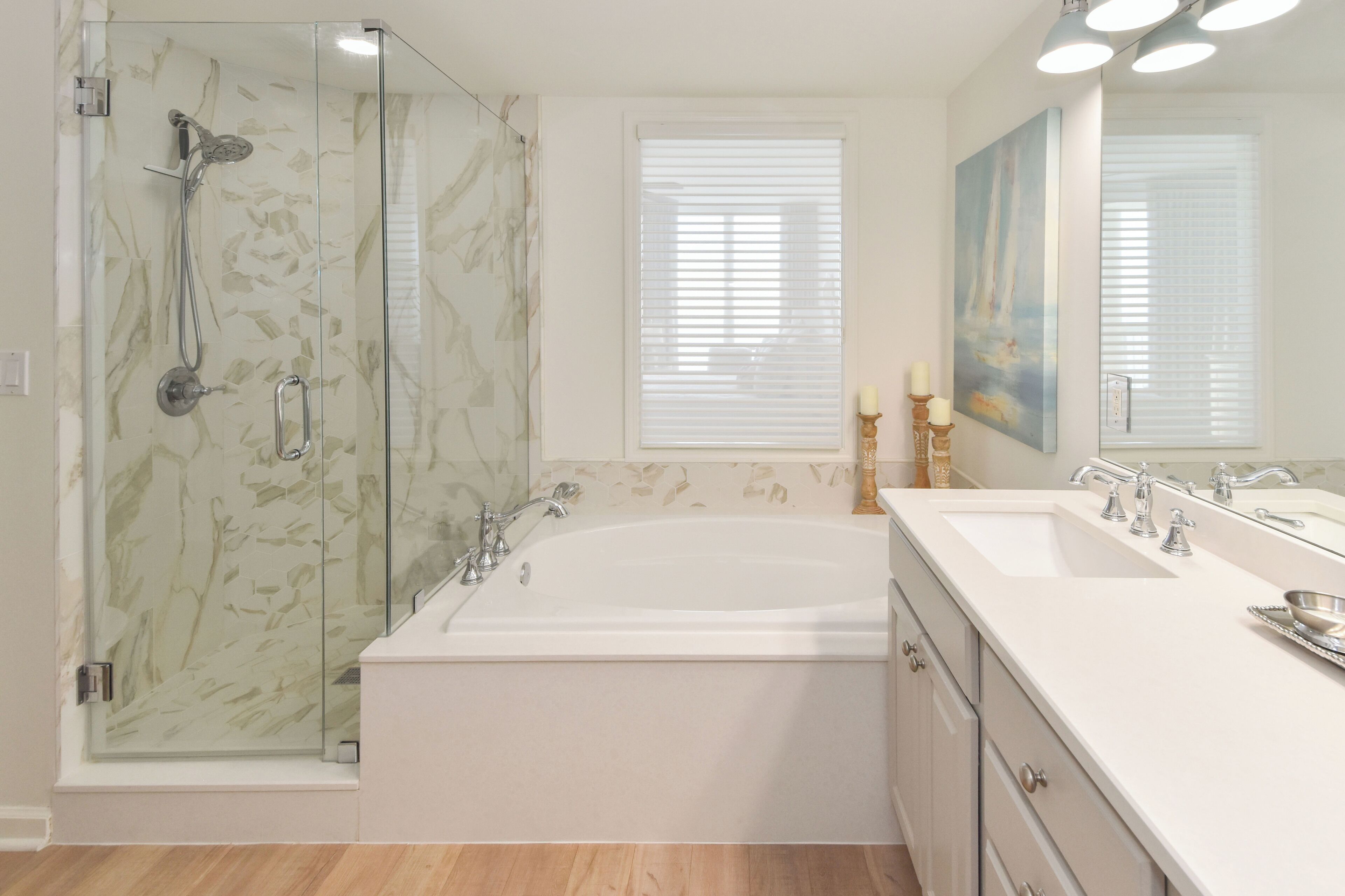 A modern bathroom with a glass-enclosed shower, a freestanding bathtub, and a vanity with a double sink.