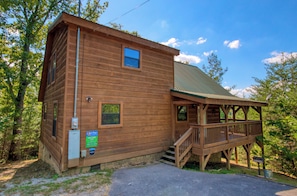 A wooden cabin with a porch and stairs leading to a deck. - Secluded | Pet Friendly | Pool Table | Arcade | Hot Tub | WiFi (SEVIERVILLE)