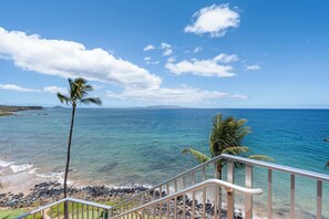 Blick auf die Küste mit blauem Himmel, einem Strand und einer Treppe, die zum Ufer hinabführt.