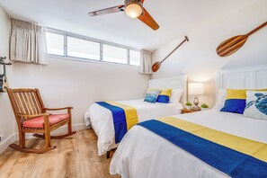 A hotel room with two beds, a rocking chair, a ceiling fan, and a window with curtains. - Updated Oceanview Oasis w/AC - Kamaole Nalu 502: Your Ultimate Maui Retreat! (Kihei)