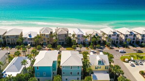A coastal residential area with multi-story buildings, a beach, and a clear sky.