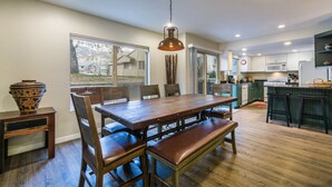 Une cuisine moderne avec une table à manger en bois, des bancs et un luminaire suspendu.