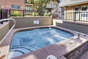 A rectangular hot tub with a metal ladder and a sign indicating a 3.5 GIN charge.