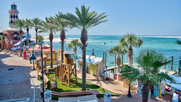 A beachside resort with a lighthouse, palm trees, and a water view. - Beautiful Renovation~Golf Course View~Golf Cart,Free Activities, Fenced Patio (Miramar Beach)