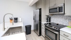 Una cucina moderna con elettrodomestici in acciaio inossidabile, un forno a microonde e una macchina da caffè.