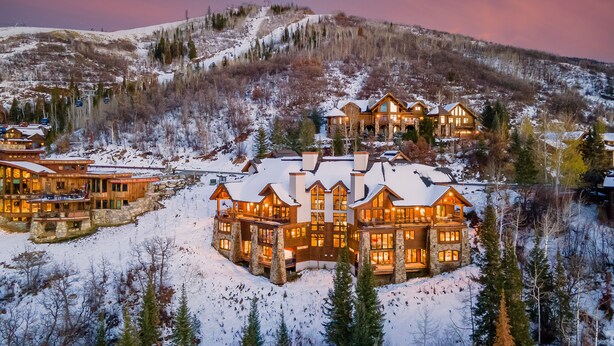 A large, multi-story lodge with a snow-covered roof, surrounded by a mountainous landscape. - Magnificent + Hot Tub + Close to Skiing - Falconhead Lodge - North (Steamboat Springs)