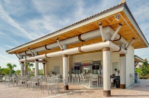 Un café en plein air doté d’un espace de repos couvert et d’une façade sur la rue.