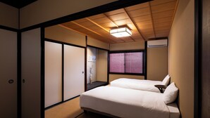 Une pièce de style japonais traditionnel, avec un sol recouvert de tatamis, un lit bas et des portes coulissantes en papier de riz (shoji).