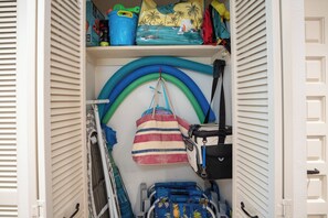 Ein Stauraum mit einem Rollstuhl, einer blauen Tasche und einer gestreiften Strandtasche.