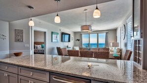 A modern kitchen with granite countertops, stainless steel appliances, and pendant lighting.
