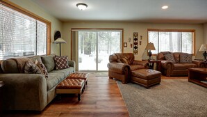 A spacious living room with a large window, a fireplace, and a cozy seating area.