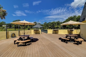 Relax outdoors with a grill station and comfortable seating under shaded umbrellas.