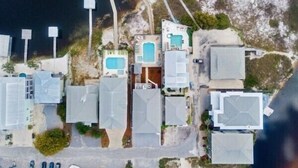 Vista aérea de un hotel costero con varias edificaciones, una piscina y una zona de playa.