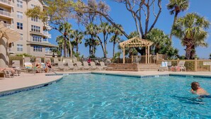 A swimming pool with lounge chairs and a gazebo. - 6304 Hampton Place- Oceanfront Views, Pool, Spa & So Much More! (Hilton Head Island)