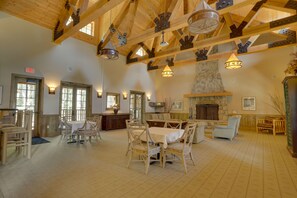 Cozy gathering space with a fireplace, dining tables, and comfortable seating options.