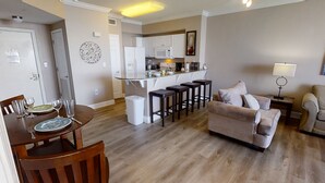 A modern apartment with a dining area, kitchen, and living room.