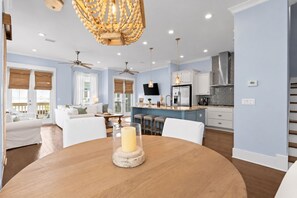A modern kitchen with white cabinets, a central island, and a chandelier.
