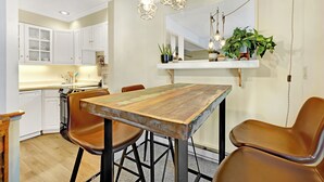 A kitchen with white cabinets, a wooden dining table, and brown chairs. - This Location Can’t Be Beat! Cozy Studio in Downtown Breckenridge l DS109 (Breckenridge)