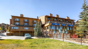 A multi-story hotel with a restaurant on the second floor, outdoor seating, and a parking area. - This Location Can’t Be Beat! Cozy Studio in Downtown Breckenridge l DS109 (Breckenridge)