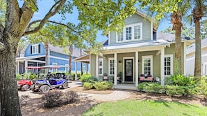 A two-story house with a porch, a driveway, and a golf cart parked outside. - ~2 Golf Carts Available*~Pool~Pets Considered, FREE Golf, Bungalo (Miramar Beach)