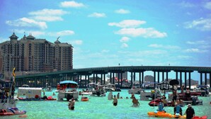 A busy waterfront with boats and people in the water, a large hotel in the background, and a pier extending into the water. - ~2 Golf Carts Available*~Pool~Pets Considered, FREE Golf, Bungalo (Miramar Beach)