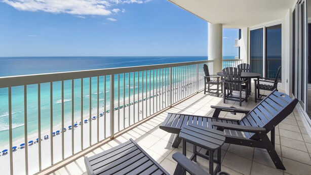 Ein Balkon mit Blick auf das Meer, Sitzgelegenheiten im Freien und einem Geländer.
