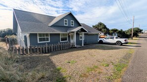 A two-story house with a gravel driveway and a white pickup truck parked in front.