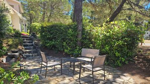 An outdoor patio with stone flooring, a table, and two chairs. - Surf Sounds Studio – Walk to the Beach, Hear the Waves! (Florence)