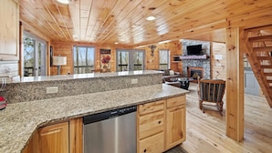 A spacious kitchen with granite countertops, wooden cabinets, and a built-in dishwasher.