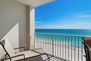 A balcony with a view of a beach and ocean.