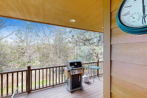 Enjoy al fresco dining on the deck overlooking the serene landscape.