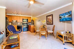 A spacious living area with a dining table, chairs, and a television.