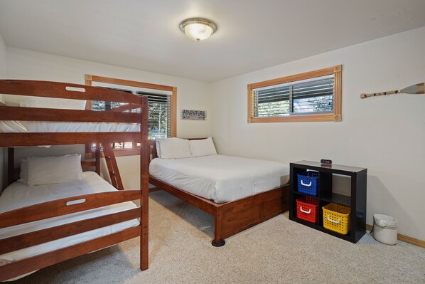 A room with a bunk bed, a single bed, a small shelf with baskets, and a wall clock. - 2 Sarazen - Golf Course Views, Hot Tub, SHARC Passes, Perfect for a Family Getaway (Sunriver)