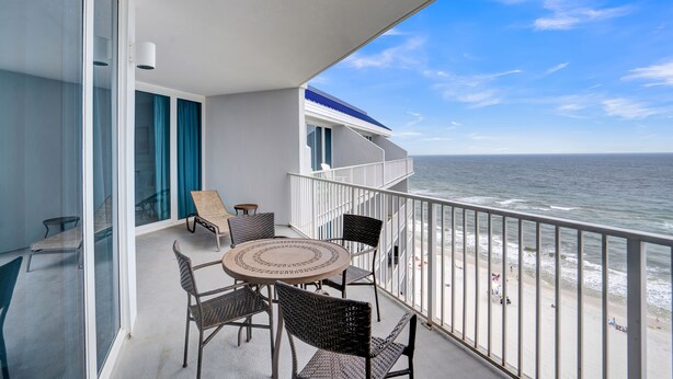 A balcony with a round table and chairs, overlooking the ocean. - Lighthouse 1404 by Liquid Life (Gulf Shores)