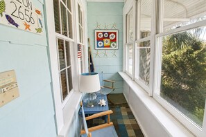 A room with a window, a lamp, a starfish decoration, and a framed picture on the wall. - Cozy, rustic home on Sullivan's Island near beach; great screen porch! (Sullivan's Island)