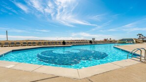 A rectangular swimming pool with a clear blue center, surrounded by lounge chairs and a concrete deck. - Beautifully Updated Phoenix VI 2BR 4th Floor Condo!! (Orange Beach)