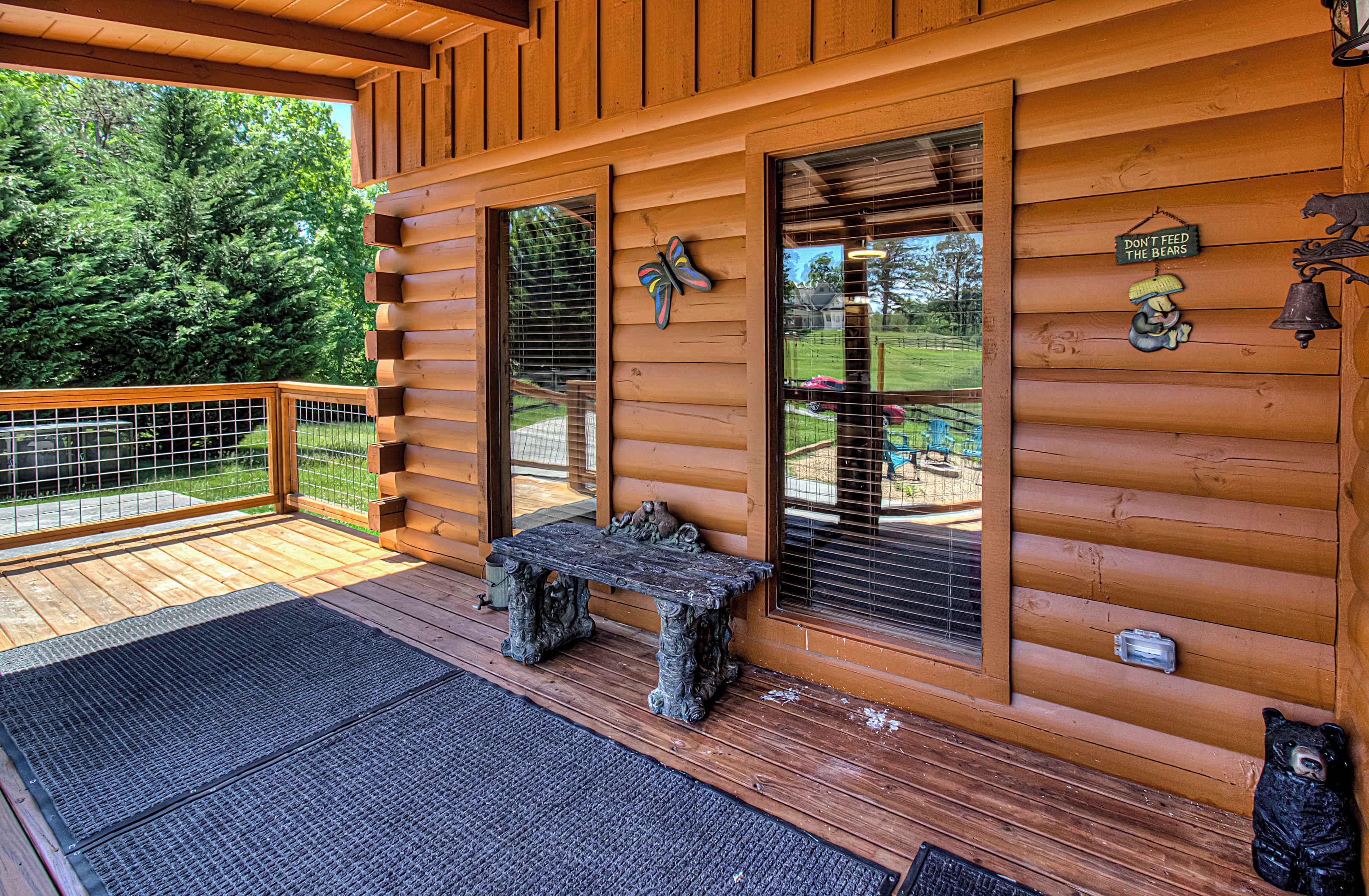 A wooden cabin with a porch, a bench, and a bear decoration.