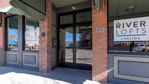 The exterior of Riverfront Rentals at 130, featuring a brick facade, large windows, and a clear view of the street. - Best location in Salida! 2 River front decks, looks over Arkansas River waterpark! (Salida)
