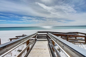Walk along the boardwalk to the sandy beach, offering a serene ocean view.