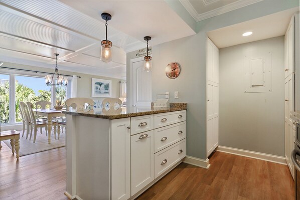 A kitchen with white cabinetry, a granite countertop, and pendant lighting. - Shorewood 312 - 3 bedroom Beautiful Ocean Front (Hilton Head Island)