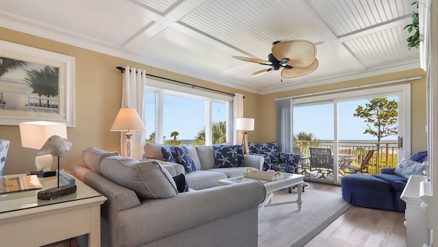 A spacious living room with a large sofa, a coffee table, and a balcony with a view. - Shorewood 312 -  3 bedroom Beautiful Ocean Front (Hilton Head Island)
