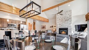 A modern kitchen with wooden beams, a stone accent wall, and a fireplace. - RENOVATED! Ski In/Out Townhome Private Hot Tub w/ Panoramic VIEWS! PINE97 (Breckenridge)