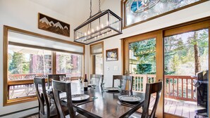 A dining area with a large table, chairs, and a hanging light fixture. - RENOVATED! Ski In/Out Townhome Private Hot Tub w/ Panoramic VIEWS! PINE97 (Breckenridge)