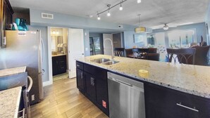 A modern kitchen with a central island, stainless steel appliances, and a dishwasher.