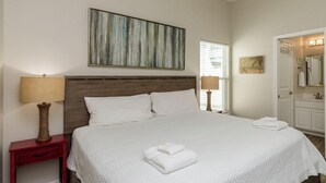 A clean, well-lit bedroom with a large bed, a nightstand, a lamp, and a mirror. - Family & Dog-Friendly Townhome | 2 Heated Pools & Beach Nearby (Corpus Christi)