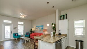 A spacious living area with a kitchen island, a ceiling fan, and a dining table. - Family & Dog-Friendly Townhome | 2 Heated Pools & Beach Nearby (Corpus Christi)