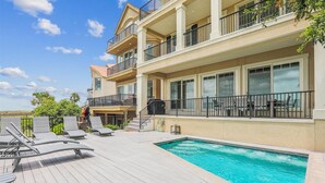 Un immeuble à plusieurs étages doté d’une piscine, d’un espace extérieur aménagé et offrant une vue sur le paysage environnant.