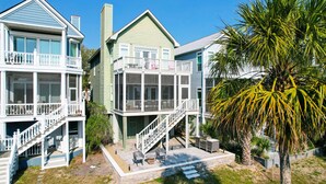 A multi-story residential building with a balcony, a staircase, and a patio area with outdoor furniture. - Stunning Ocean Views, Just steps to the Pool! 32 Ocean Pt (Isle of Palms)