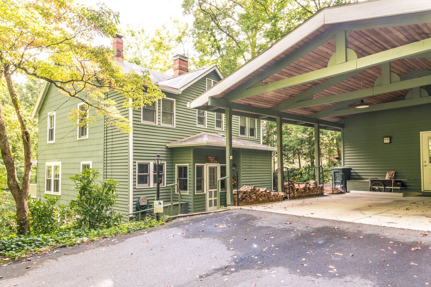 A green building with a covered porch, a front door, and a sign that reads "Pine Lodge."