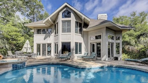A two-story house with a swimming pool, outdoor seating, and a large window overlooking the pool. - 37 St. George - 5 minute walk to the beach! (Hilton Head Island)